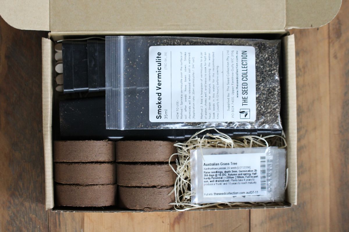 An open gift box with seeds, vermiculite, soil pellets and tubes